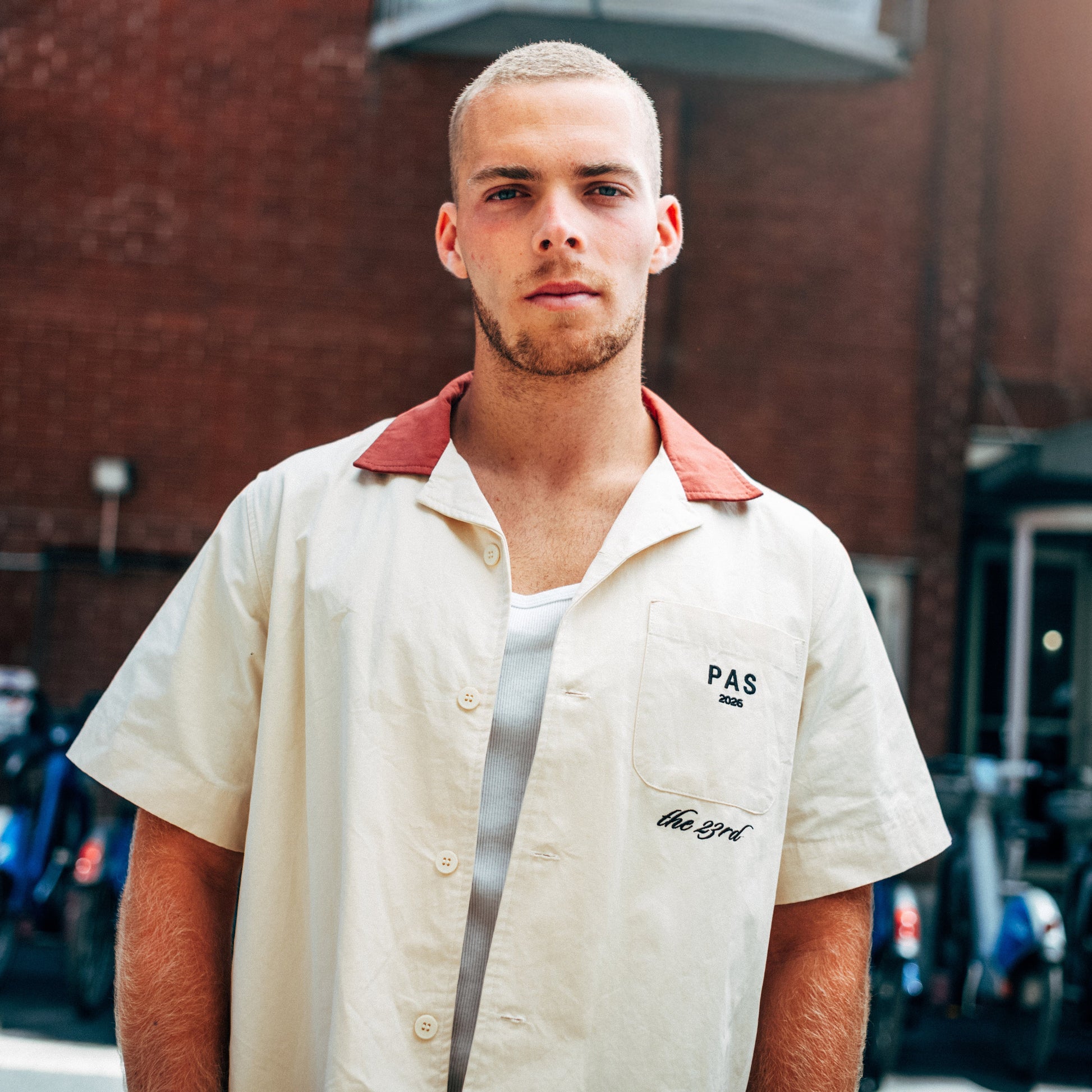 PAS The 23rd One Tribe cream button-up shirt – soccer streetwear with embroidered crest back graphic, worn in New York City